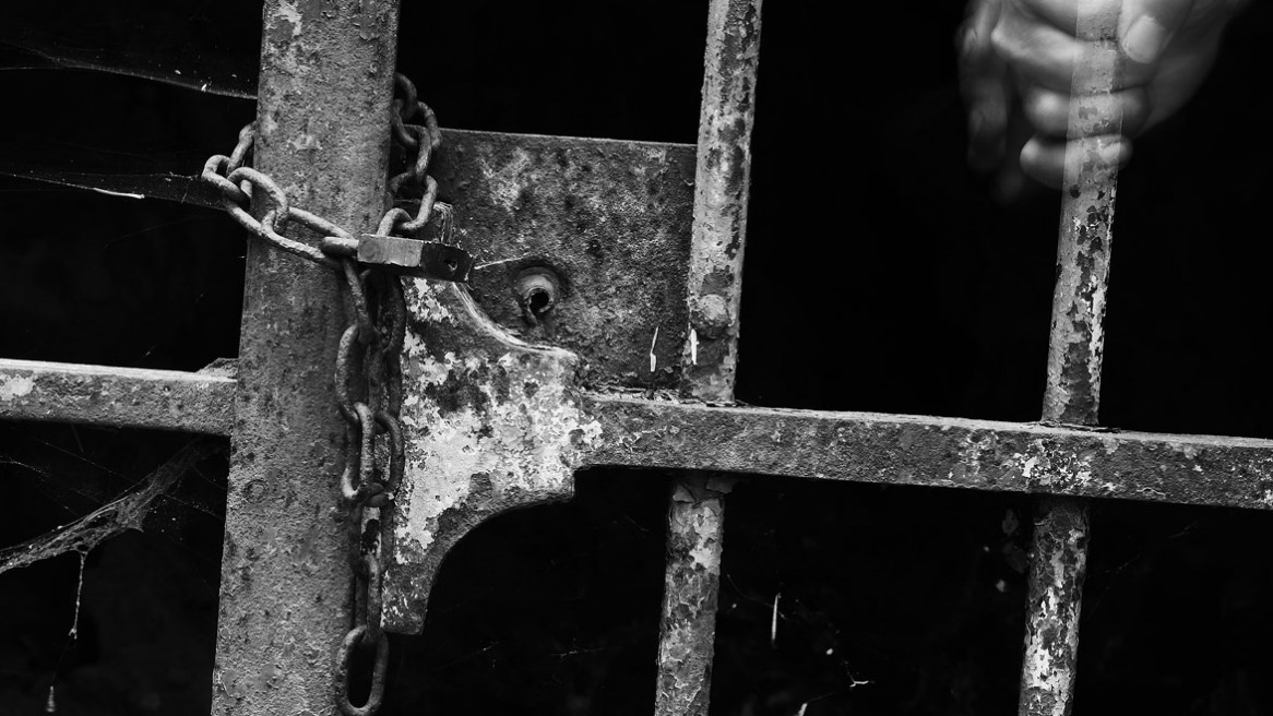 Une main serrant le barreau d'une grille - Photo noir et blanc de Matthieu Dupont