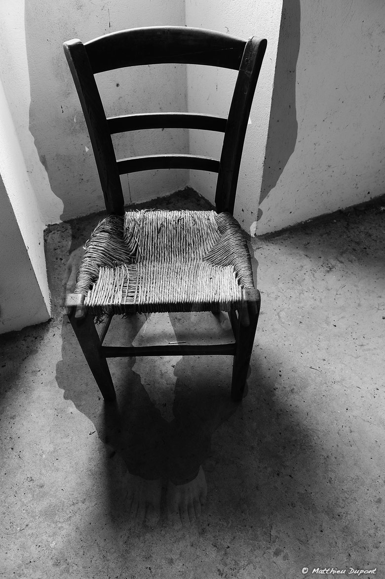 Une chaise, une silhouette humaine qui s'efface, un contre-jour... Photo noir et blanc de Matthieu Dupont