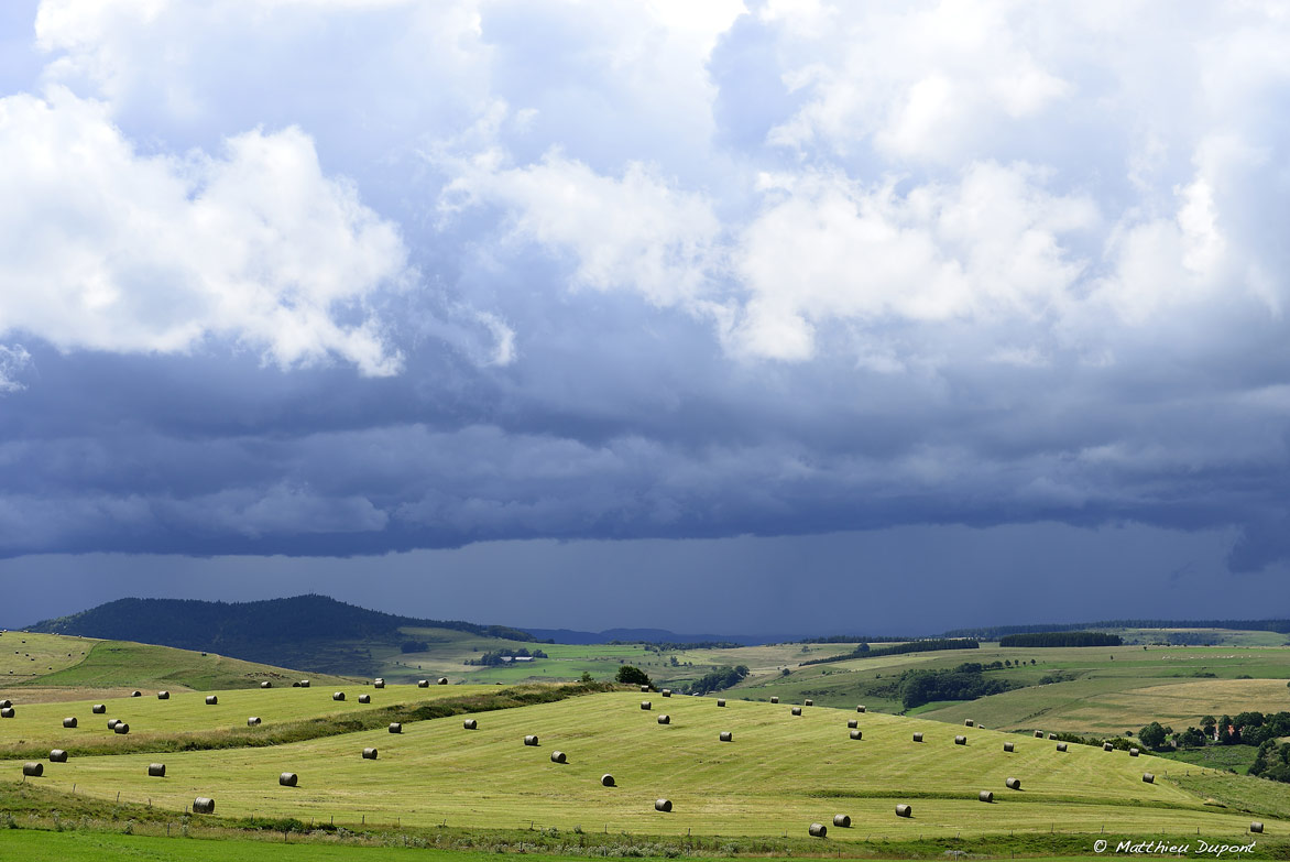 Paysage ardéchois sculpté par les balles de foin, sous un ciel orageux. Photo Matthieu Dupont