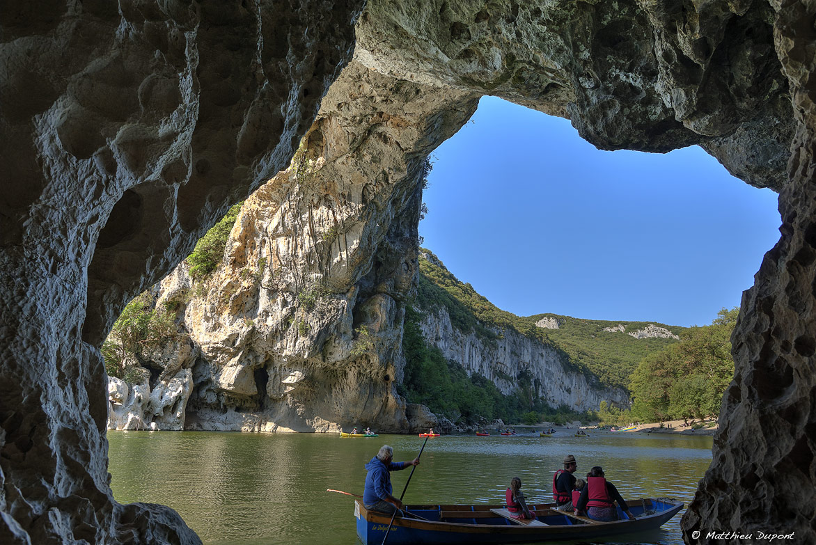 Famille en barque sous l'arche du Pont d'Arc en Ardèche. Photo Matthieu Dupont