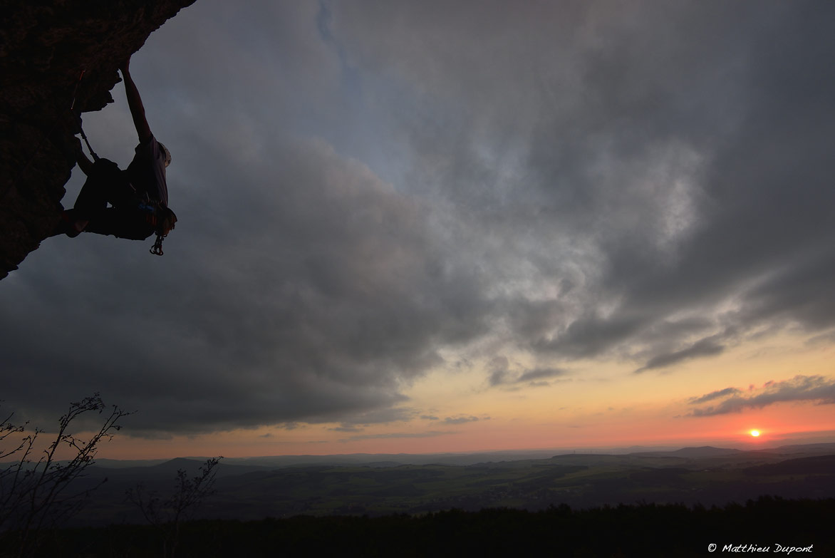 Grimpeur au coucher du soleil sur le site d'escalade des Coux en Ardèche. Une photo de Matthieu Dupont