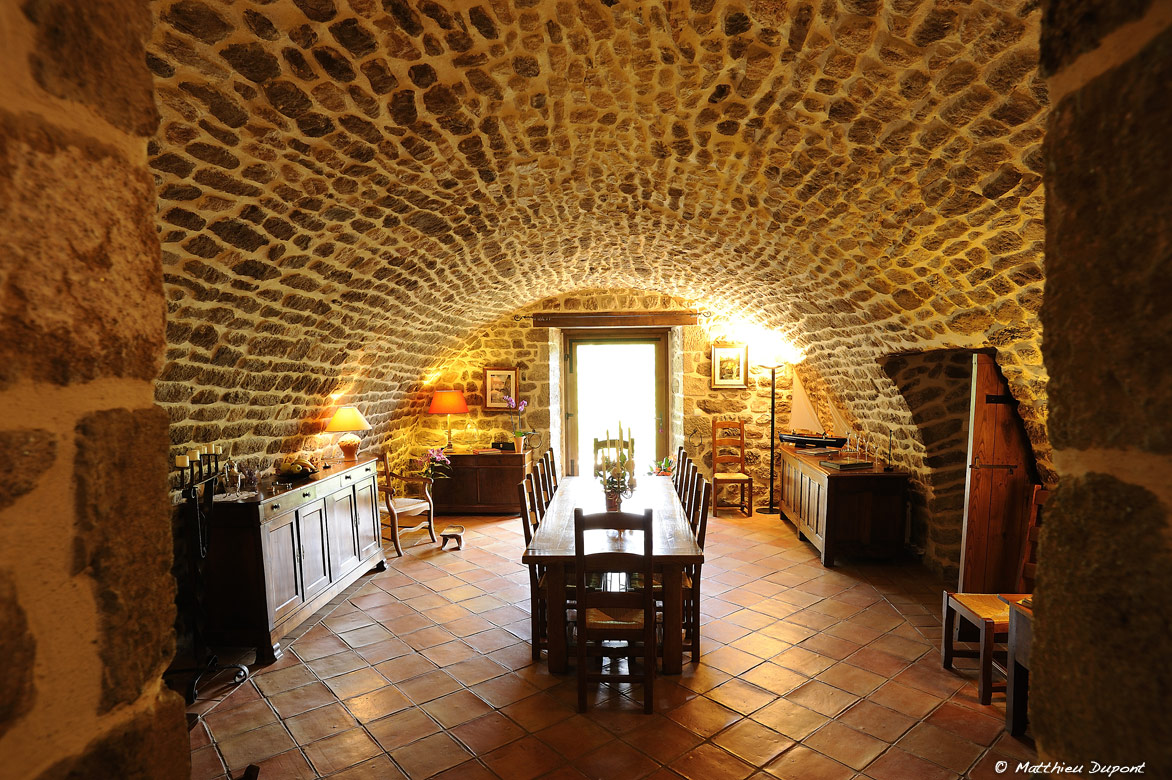 La salle à manger d'une table d'hôte en Ardèche. Une belle voute en pierre typique de la région.