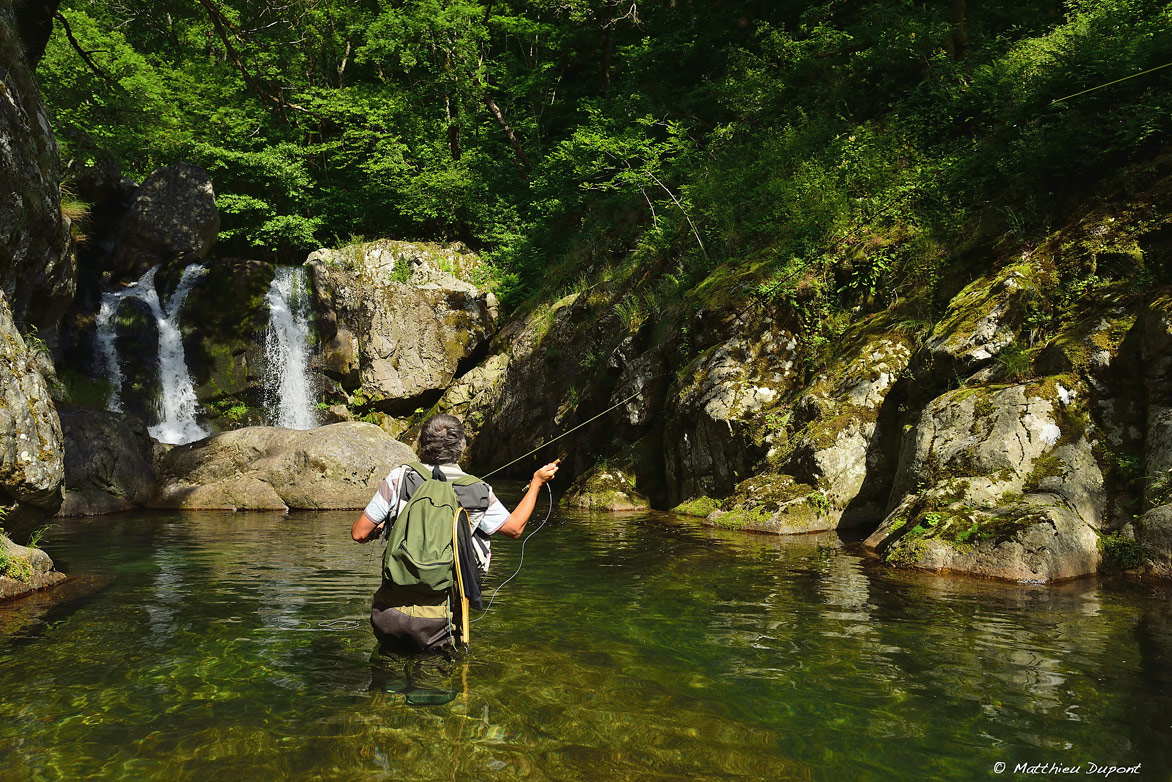 Un pêcheur à la mouche au pied d'une petite cascade sur la rivière Borne en Ardèche. Une photo de Matthieu Dupont