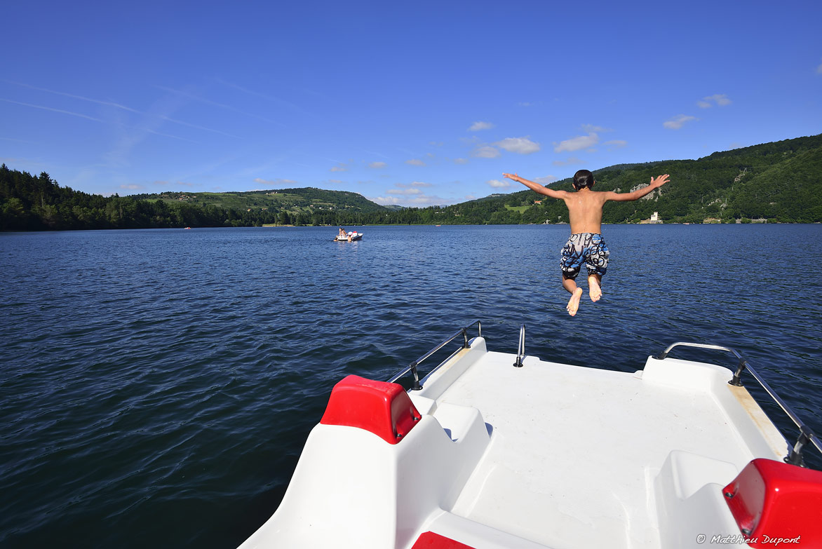 Un enfant saute d'un pédalo au Lac d'Issarlès en Ardèche. Photo Matthieu Dupont