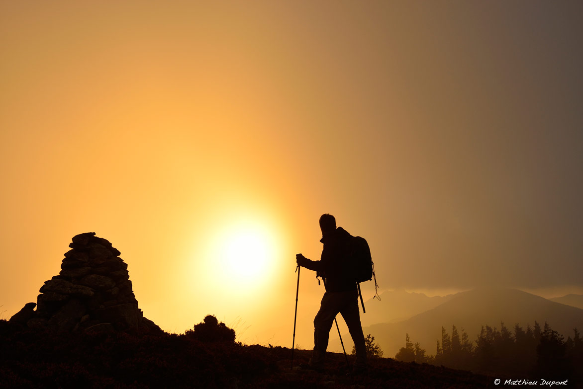 Un randonneur au lever du soleil sur la Montagne ardéchoise. Photo Matthieu Dupont
