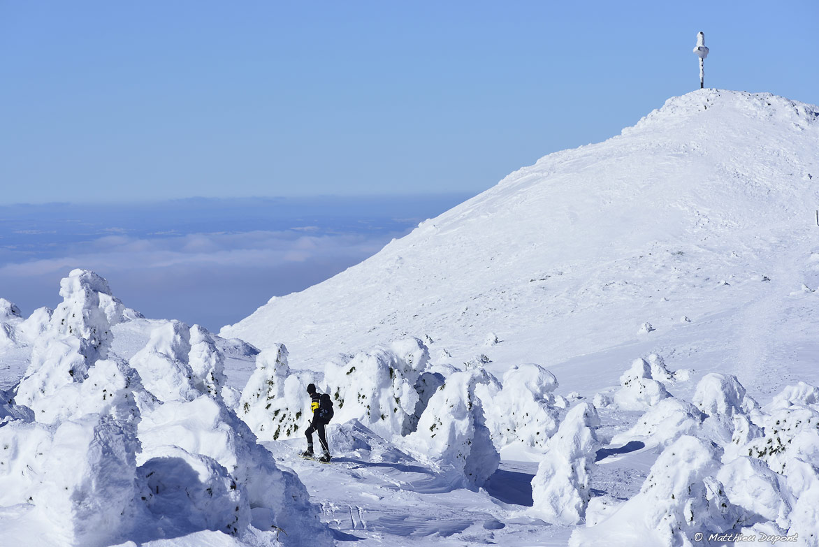 Randonneur en raquette au sommet du Mont Mézenc (Ardèche), au milieu des congères. On aperçoit la croix entièrement recouverte de neige. Photo Matthieu Dupont